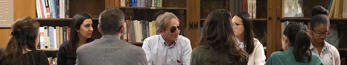Banner, Faculty with Students sitting around a table. 
