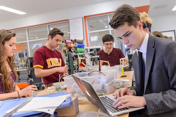 A young male student studies on his laptop at the SMU Lyle 